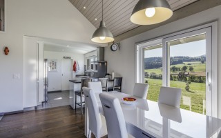 Salle à manger ouverte sur la cuisine avec accès à la terrasse